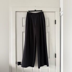 Toccin sleek trousers with front pleats, wide legs, and back welt pockets